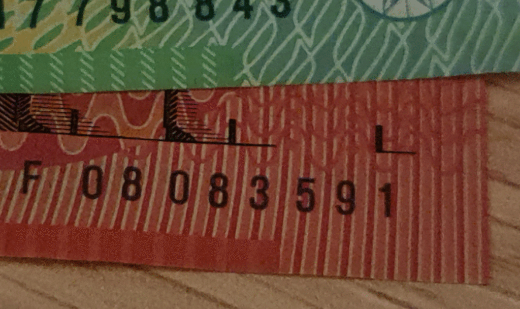 Animated GIF of an Australian banknote serial number fluorescing under UV light